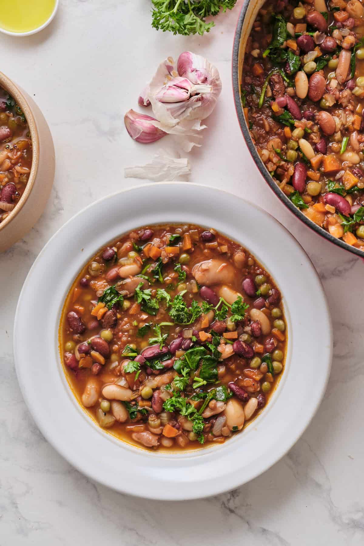 Hearty vegan bean soup with fresh herbs, carrots, spinach, and a flavorful broth, perfect for clean eating and plant-based health meals.