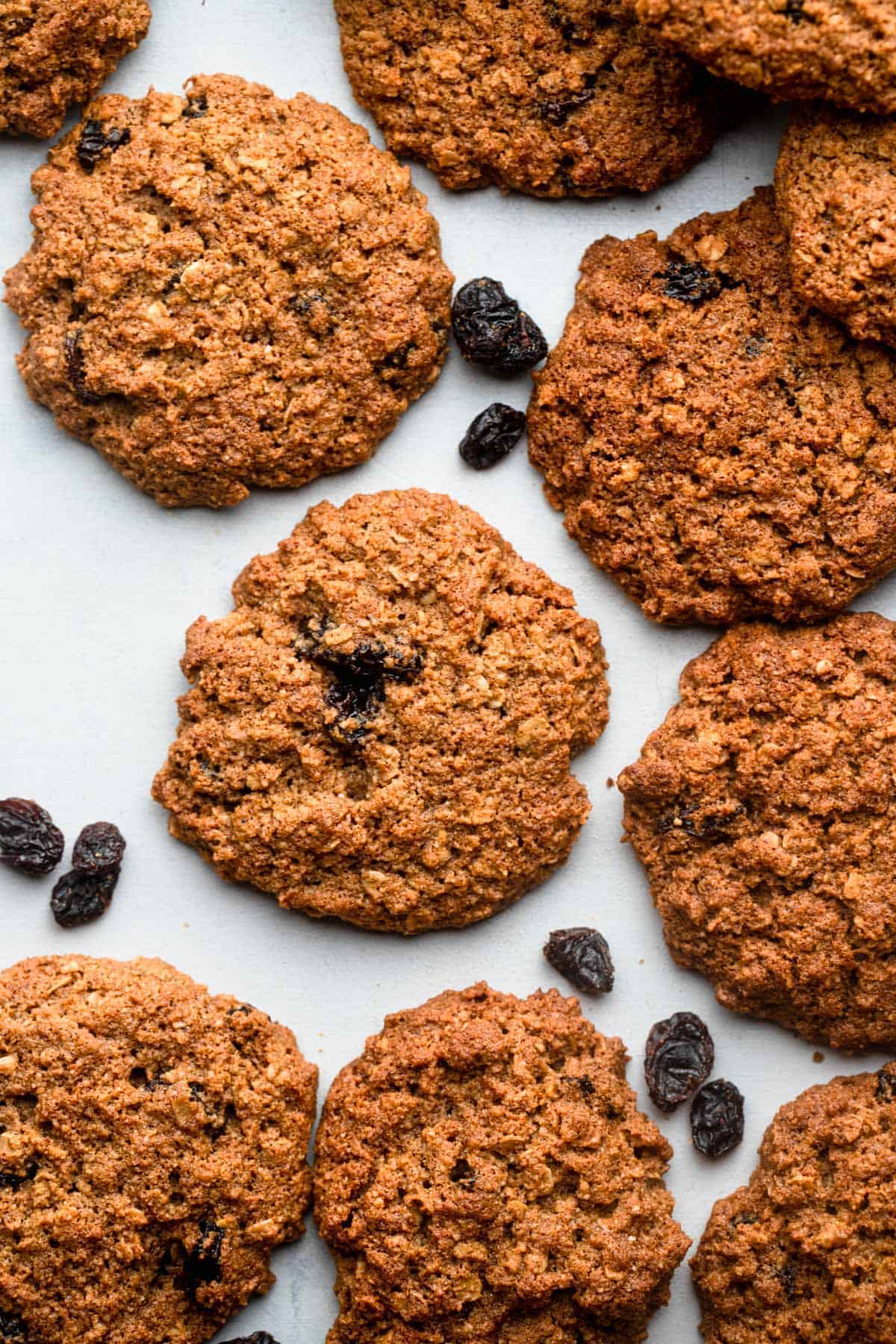 Almond Flour Oatmeal Cookies on a baking sheet with raisins around it