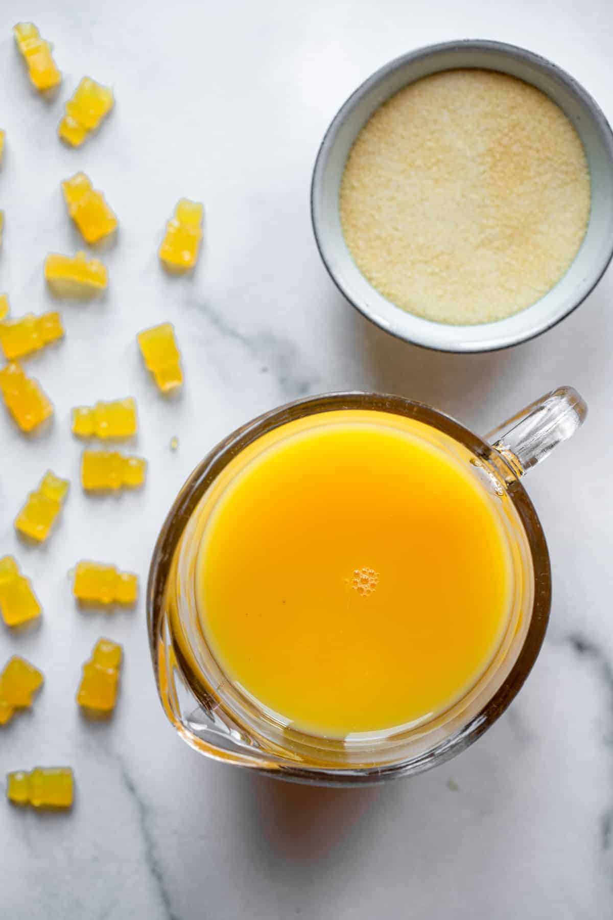 close up of orange juice and gelatin for making the healthy gummies