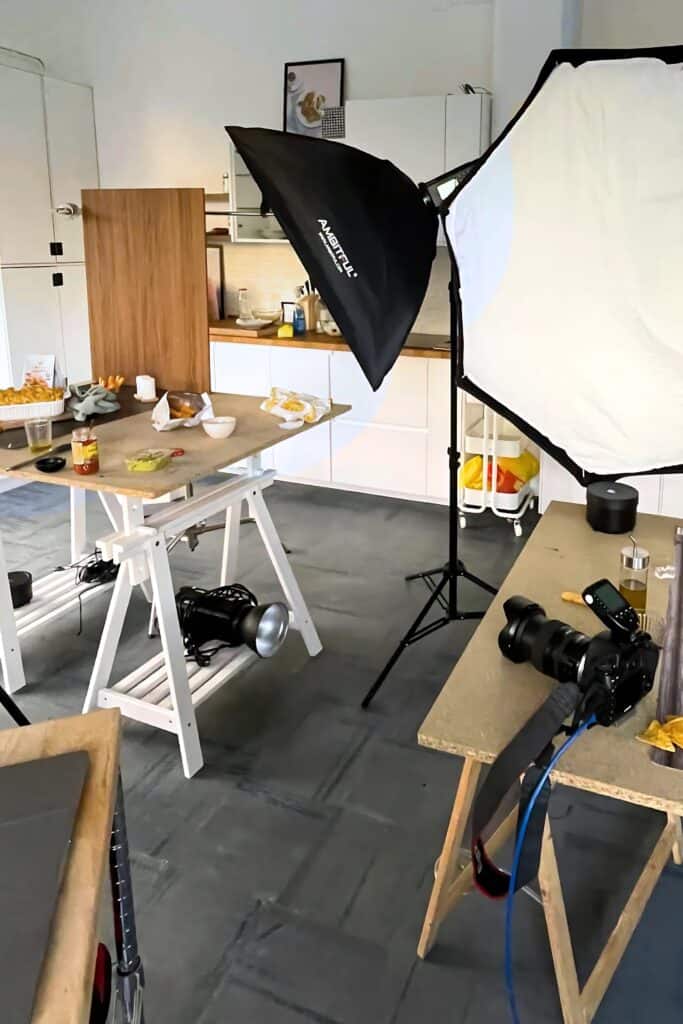Professional food photography studio setup with lighting equipment and various food props for healthy meal content creation.