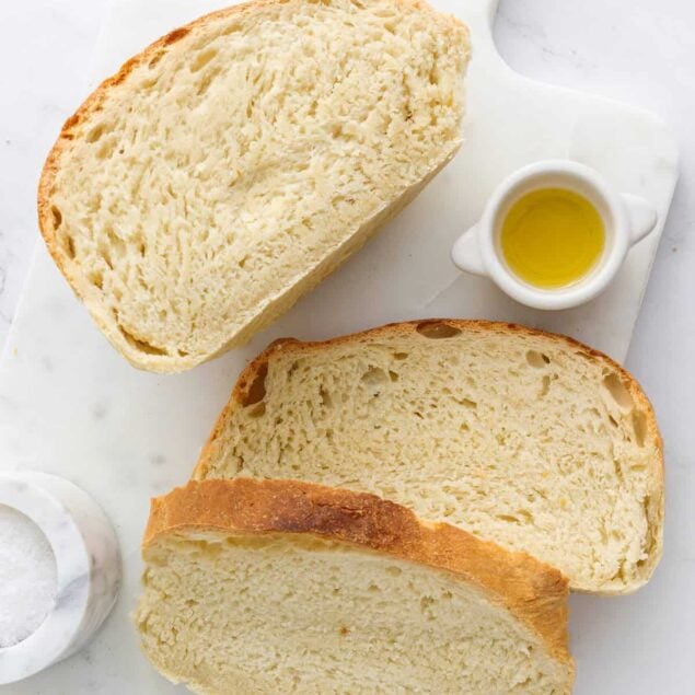 Fluffy homemade bread with a golden crust, served with olive oil and sea salt, perfect for healthy eating and nutritious meals.