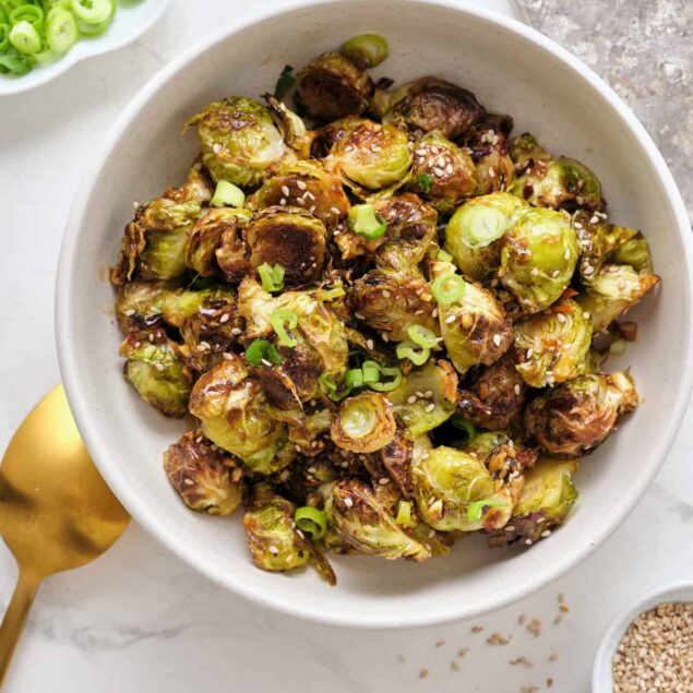 Roasted brussels sprouts with sesame seeds and green onions on white bowl, healthy vegetarian side dish, easy nutritious recipe, Food Faith Fitness.