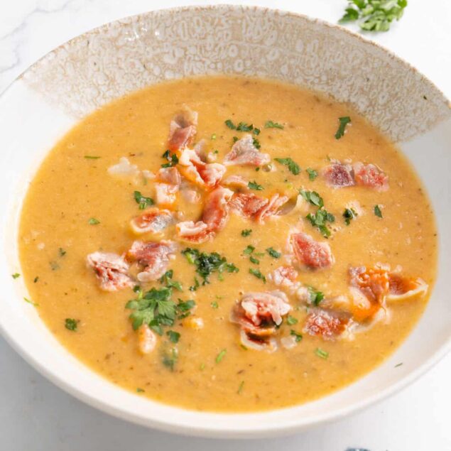 Creamy bacon and potato soup garnished with fresh herbs, perfect for a healthy meal on Food Faith Fitness recipes.