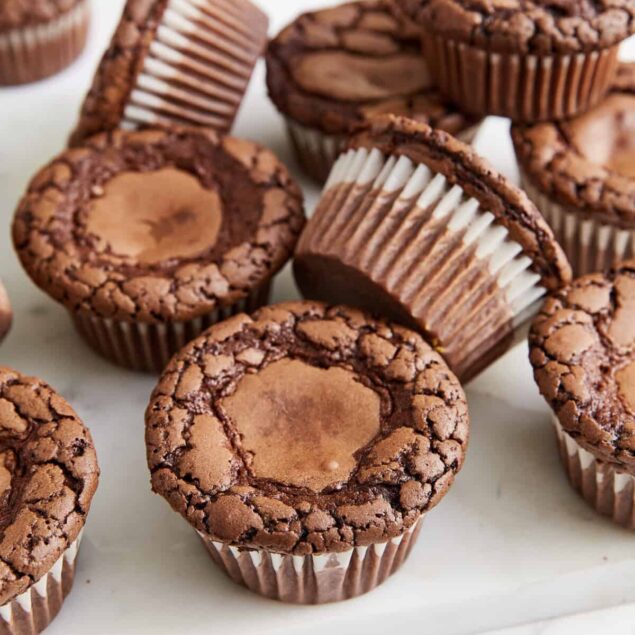 Decadent gluten-free chocolate peanut butter cups on white marble surface, perfect healthy dessert recipe.