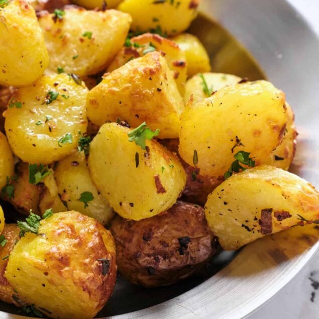Creamy roasted potatoes garnished with fresh herbs, perfect for healthy meal prep and nutritious eating.