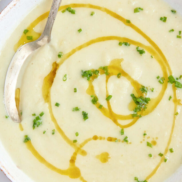 Creamy potato leek soup garnished with fresh chives and a drizzle of olive oil, perfect for healthy eating and meal prep.