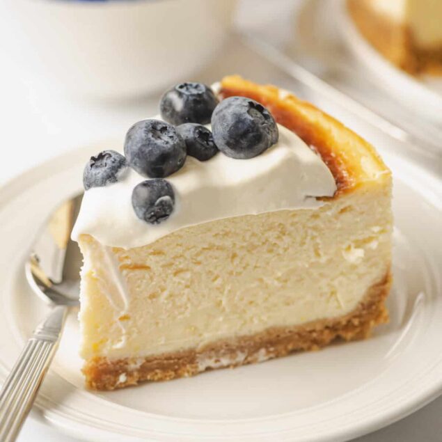 Creamy cheesecake topped with fresh blueberries on a white plate, highlighting healthy dessert options and berry toppings for a nutritious treat.