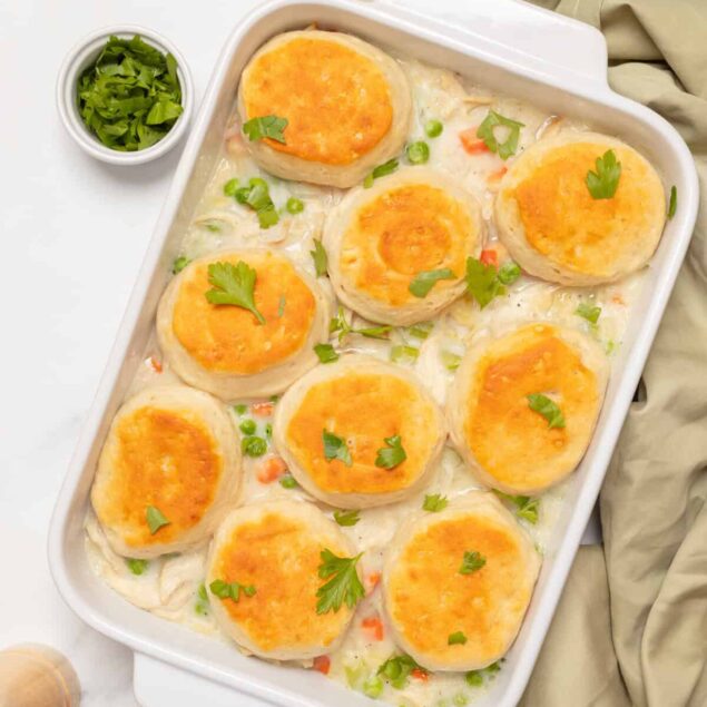 Savory chicken and vegetable casserole topped with melted cheese and fresh herbs, perfect for healthy meal prep and balanced nutrition from Food Faith Fitness.
