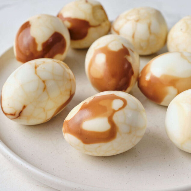 Marbled white chocolate eggs on a ceramic plate, perfect for healthy holiday treats or protein-rich snacks, emphasizing nutritious and indulgent recipes.