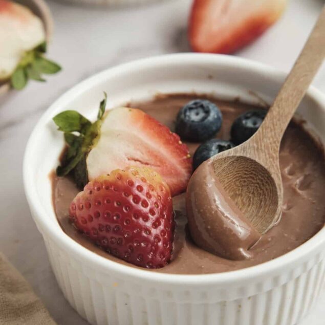 Rich chocolate avocado pudding with fresh strawberries and blueberries, healthy dessert recipe, dairy-free, plant-based snack, low-sugar indulgence, food faith fitness recipe.