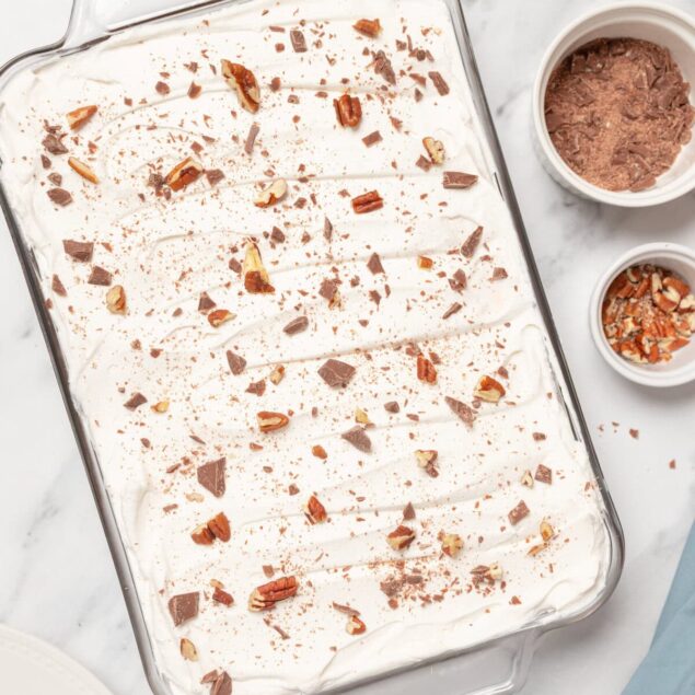 Rich chocolate and whipped cream no-churn ice cream with chopped nuts on top, served in a glass baking dish, perfect for healthy dessert recipes and indulgent treats.