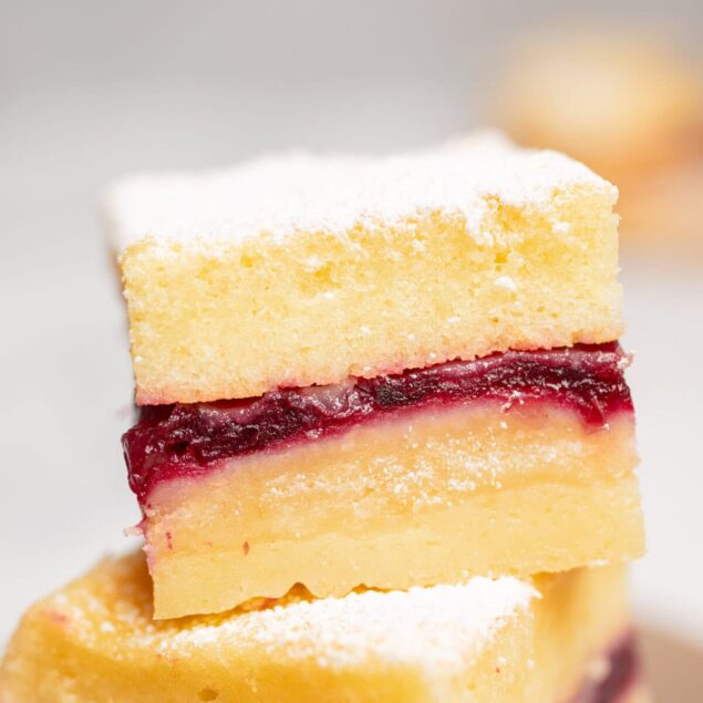 Vanilla sponge cake layered with cherry jam and dusted with powdered sugar, showcasing delicious dessert recipes from Food Faith Fitness.