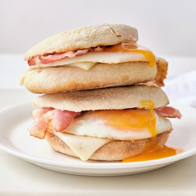 Fluffy breakfast sandwiches with eggs, bacon, and melted cheese on English muffins, perfect for a nutritious morning meal.