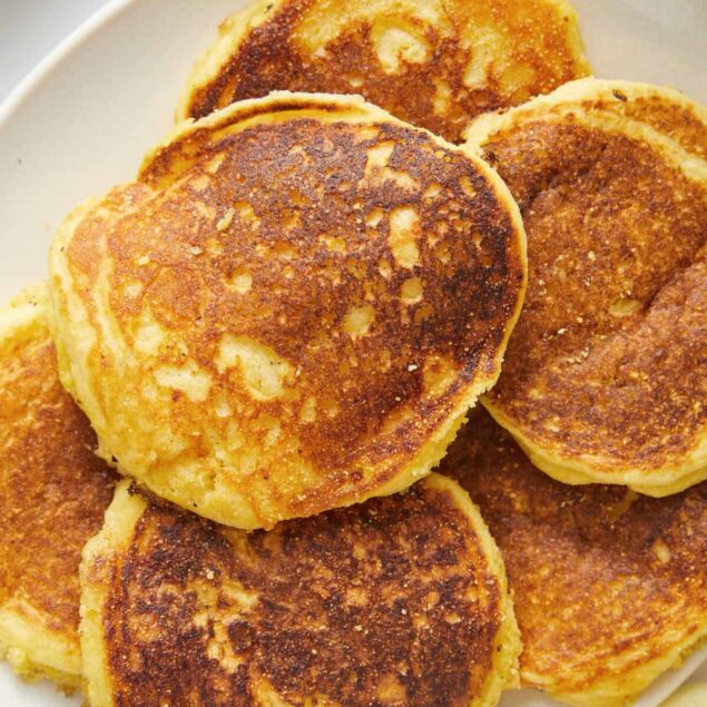 Fluffy, golden-brown pancakes on a white plate, perfect for a healthy breakfast or brunch, emphasizing comfort food with a nutritious twist.