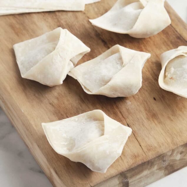 Delicious homemade dumplings on a wooden cutting board, showcasing fresh, hand-rolled dough and perfect for healthy recipes and easy meal prep.