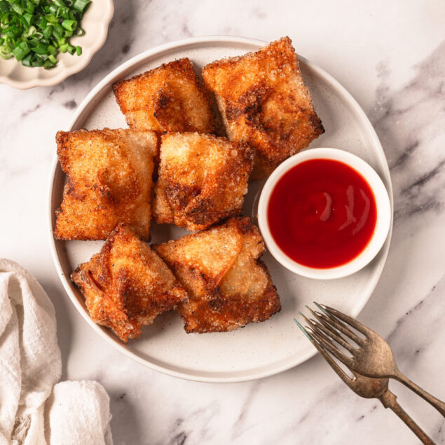 Golden crispy egg rolls served with sweet chili sauce, accompanied by chopped green onions and soy sauce for dipping, perfect for healthy eating and easy meal ideas on Food Faith Fitness.