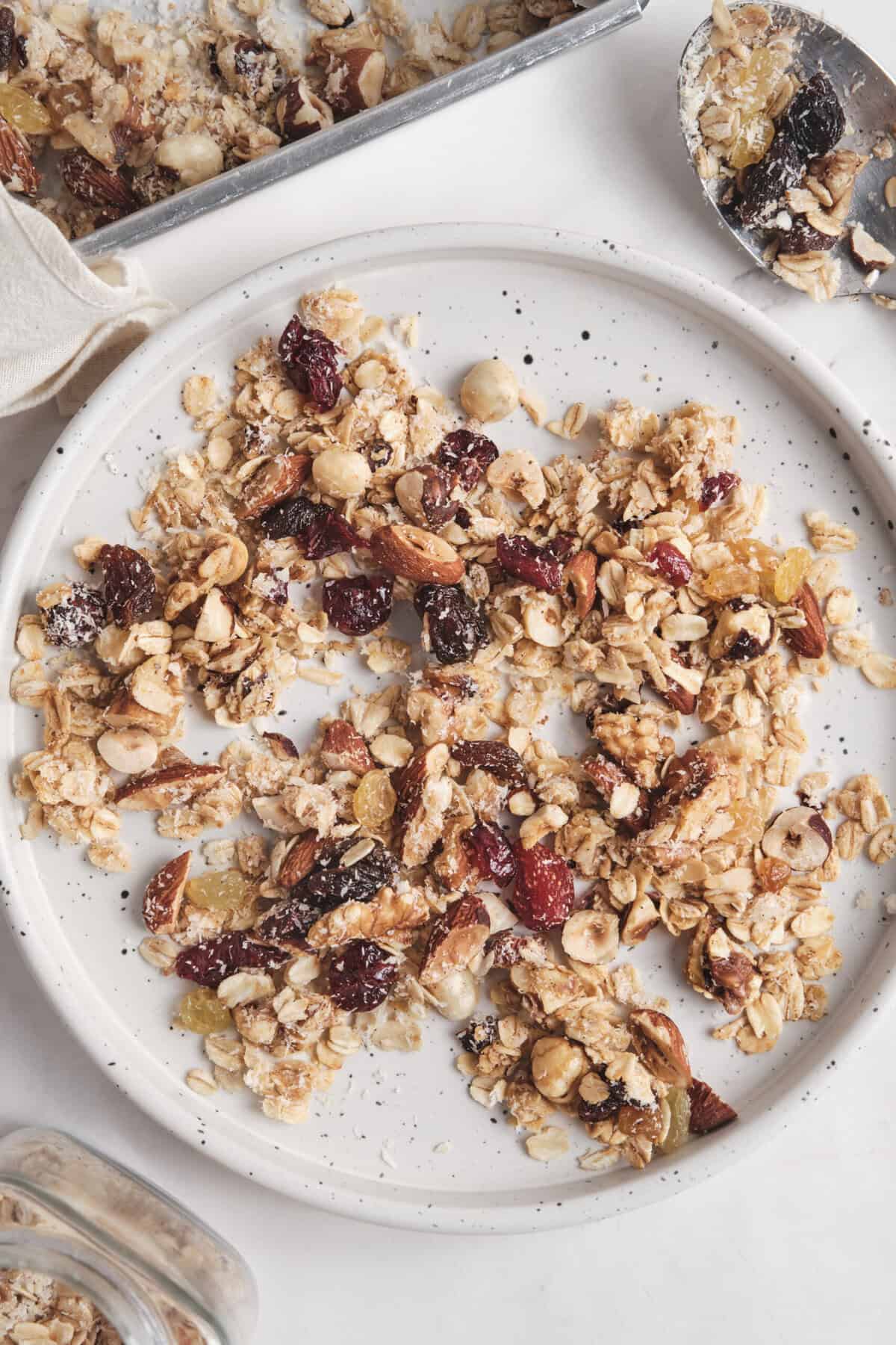 Crunchy homemade healthy granola with nuts, seeds, and dried fruit on a white plate, ideal for wholesome snacking and breakfast. Perfect for a nutritious lifestyle aligned with Food Faith Fitness principles.