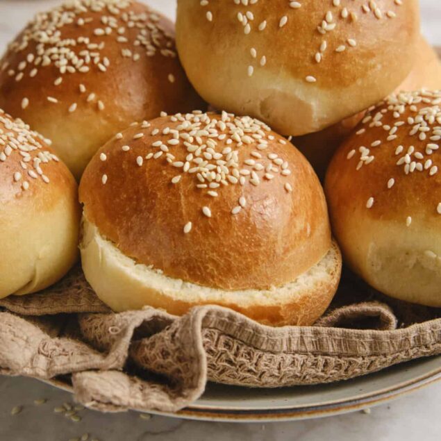 Golden-brown sesame seed dinner rolls on a rustic plate, fresh and soft, perfect for healthy meal ideas and snack recipes.