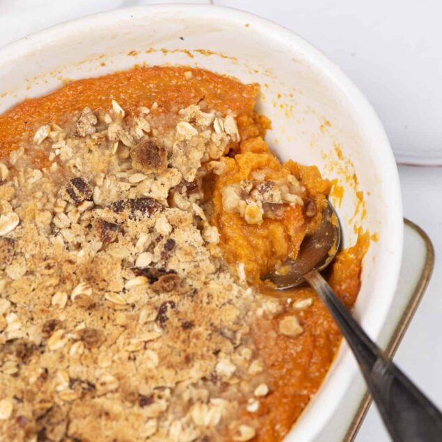 Creamy sweet potato casserole topped with crunchy oat crumble and chopped nuts, perfect for healthy holiday meals and nutritious side dishes.
