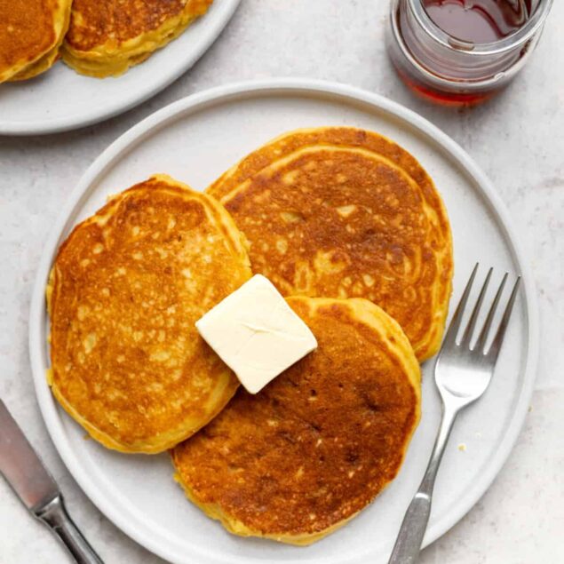 Fluffy homemade pancakes with butter and syrup, perfect for a healthy breakfast option, from Food Faith Fitness. Nutritious, delicious recipes for breakfast lovers.