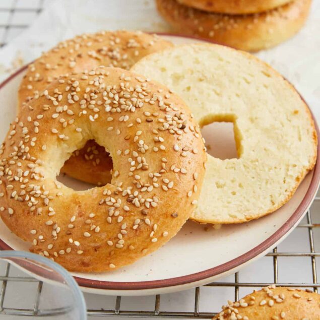 Golden sesame bagels with a soft interior on a ceramic plate, fresh and homemade, perfect for healthy breakfast options or nutritious snacks.