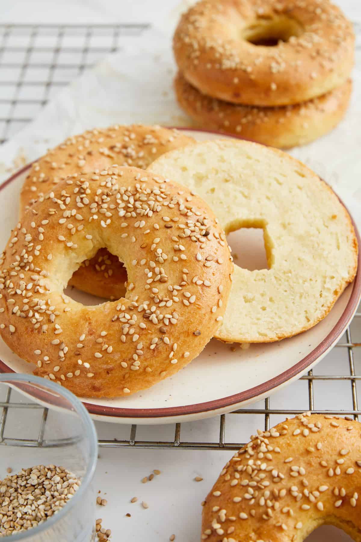 Golden sesame bagels with a soft interior on a ceramic plate, fresh and homemade, perfect for healthy breakfast options or nutritious snacks.
