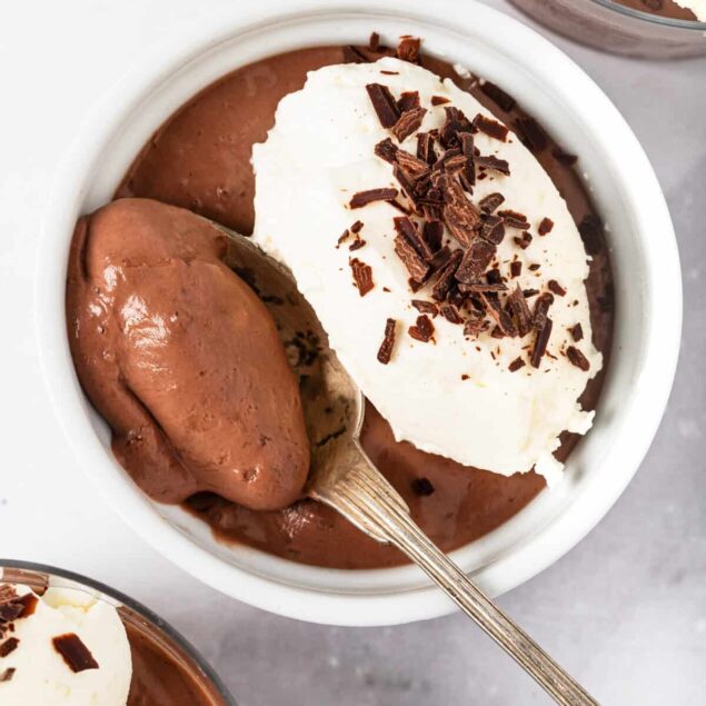 Rich chocolate pudding topped with whipped cream and chocolate shavings, perfect for healthy dessert recipes and indulgent treats.