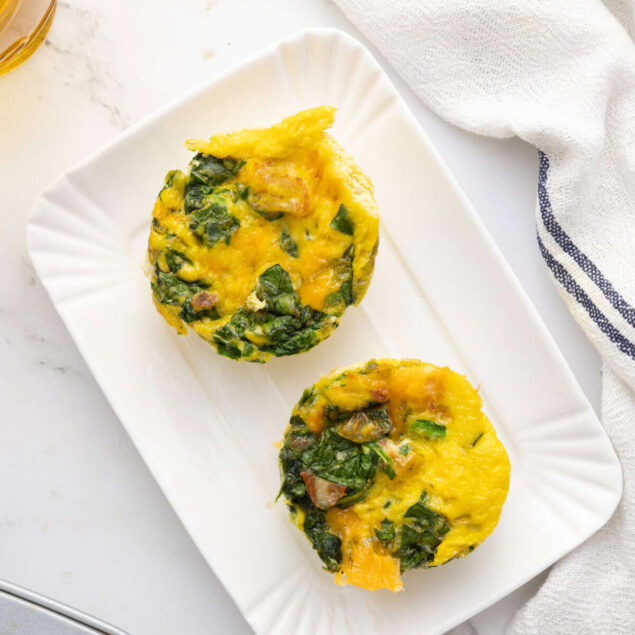 Savory vegetable egg muffins with spinach and peppers on white plate, healthy breakfast ideas, high-protein low-carb meal, meal prep breakfast, wholesome clean eating, Food Faith Fitness recipe.