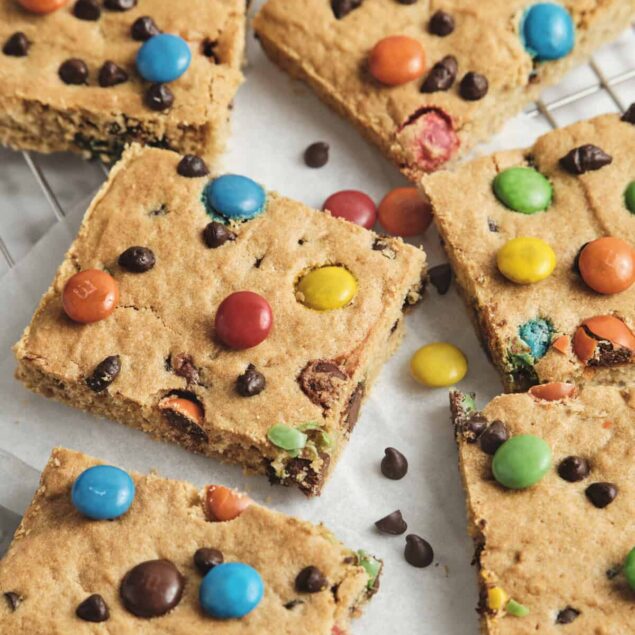 Bright colorful peanut butter cookie bars topped with M&Ms and chocolate chips, featuring a chewy texture and vibrant appearance, perfect for healthy desserts or snack recipes.