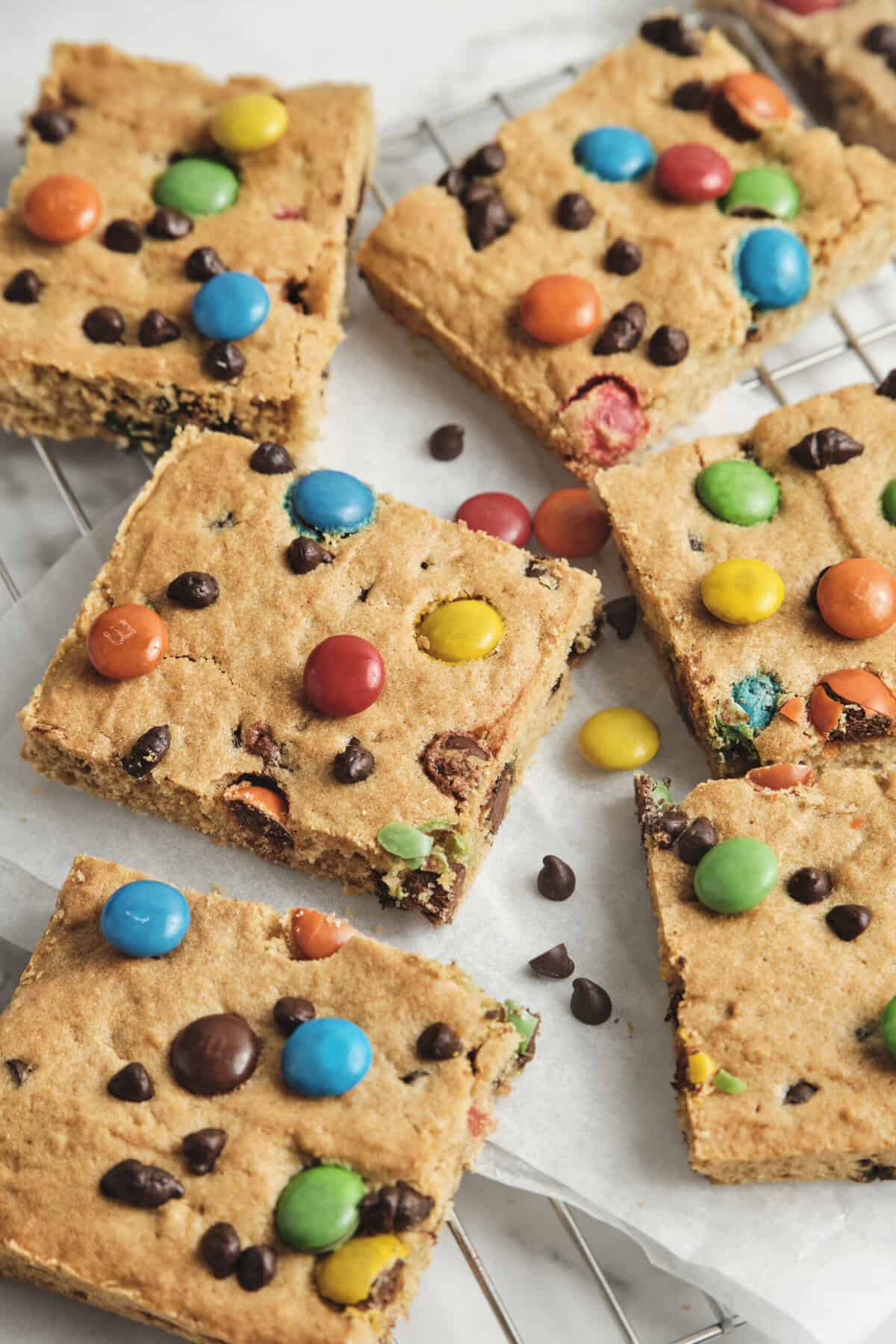 Bright colorful peanut butter cookie bars topped with M&Ms and chocolate chips, featuring a chewy texture and vibrant appearance, perfect for healthy desserts or snack recipes.