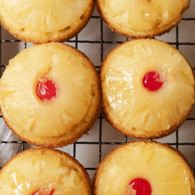 Fresh pineapple upside-down cupcakes topped with maraschino cherries, perfect for a healthy dessert or snack, featuring moist cake and tropical fruit flavor from Food Faith Fitness.