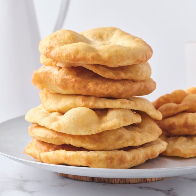 Golden fried doughnuts stacked on a white plate, perfect for a gluten-free or healthy snack. Crafted with nutritious ingredients for a delicious treat that fits into balanced eating and wellness routines.