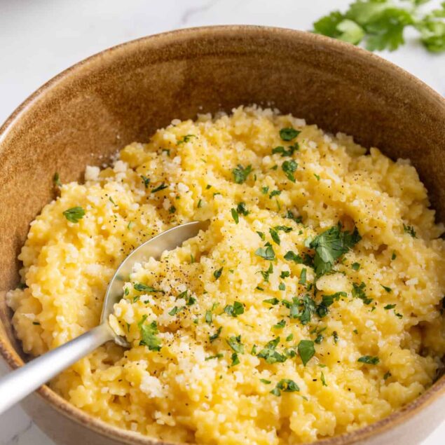Creamy scrambled eggs garnished with fresh herbs in a rustic bowl for a healthy breakfast.