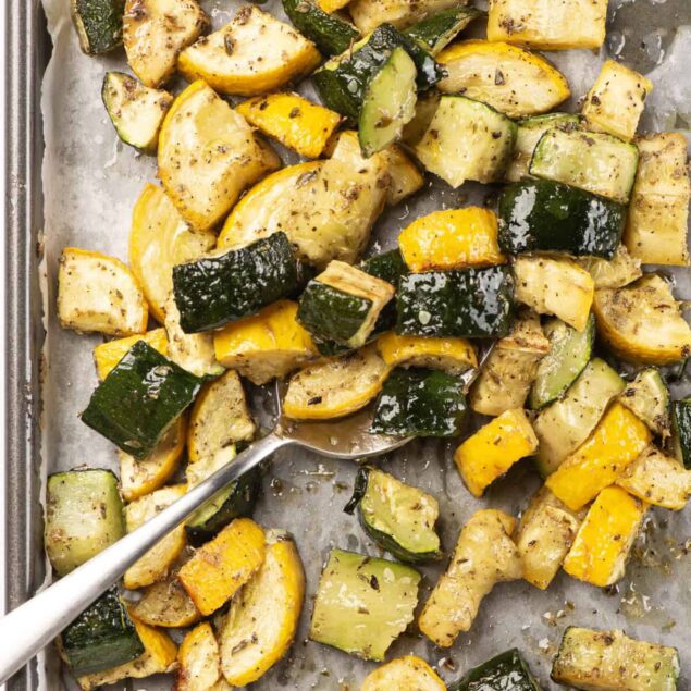 Roasted zucchini and yellow squash with herbs on baking sheet, healthy vegetable side dish, gluten-free, vegan, low-carb dinner option.