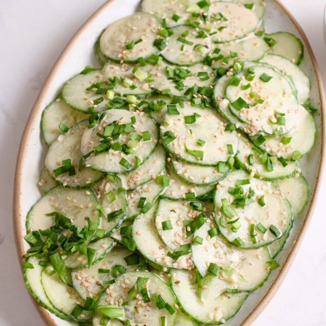 Fresh cucumber salad with creamy tahini dressing, chopped green onions, and sesame seeds, perfect for healthy meal ideas and weight loss meal prep. Easy to make and nutritious.
