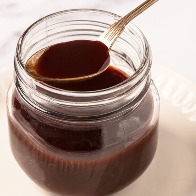 Rich homemade chocolate syrup in glass jar ready for baking or dessert topping. Perfect for adding flavor to cakes, ice cream, pancakes, and other delicious treats. A key ingredient in healthy, flavorful recipes.