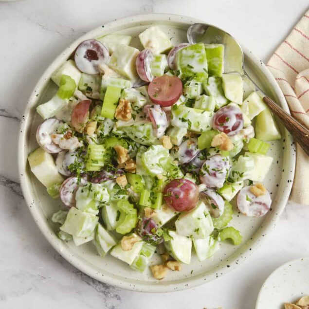 Crisp cucumber and fresh grape tomato salad with creamy dressing, chopped walnuts, and herbs in a white ceramic bowl. Perfect for healthy eating, summer meals, or side dishes.