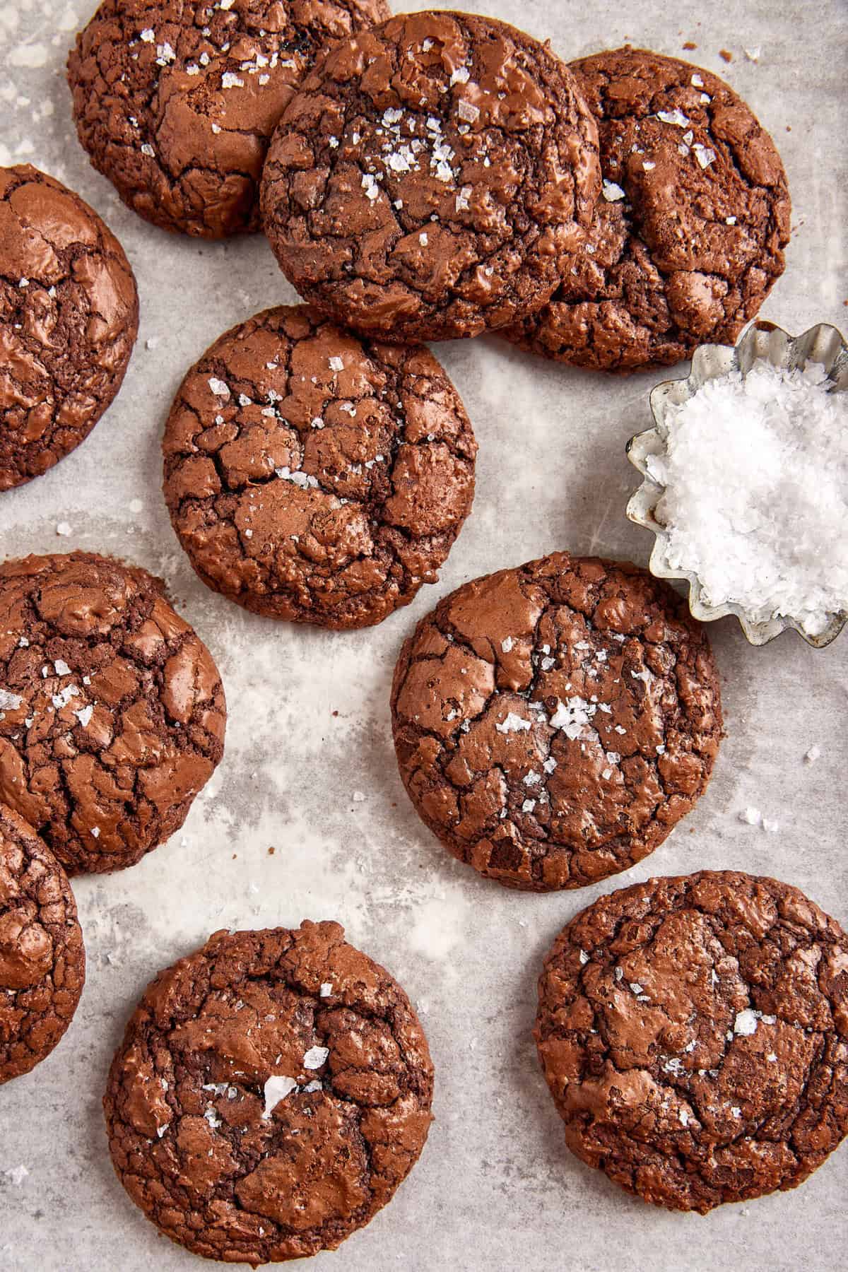 Fudgy chocolate cookies with sea salt on parchment paper, perfect for healthy dessert recipes.