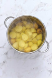 Boiled yellow potatoes in a stainless steel pot, top view, healthy vegetarian meal ingredients, simple home cooking essentials, food preparation for nutritious recipes.