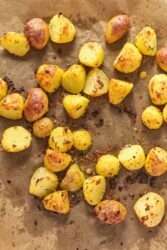 Roasted baby potatoes with crispy skins and herbs on a baking sheet. Perfect for healthy dinner recipes, meal prep, and side dishes, these easy roasted potatoes are delicious and nutritious.