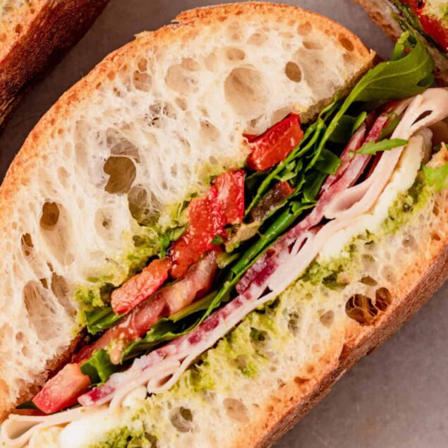Freshly made vegetable and turkey sandwich on whole grain bread with lettuce, tomato, and avocado spread, perfect for healthy eating and nutritious meals.