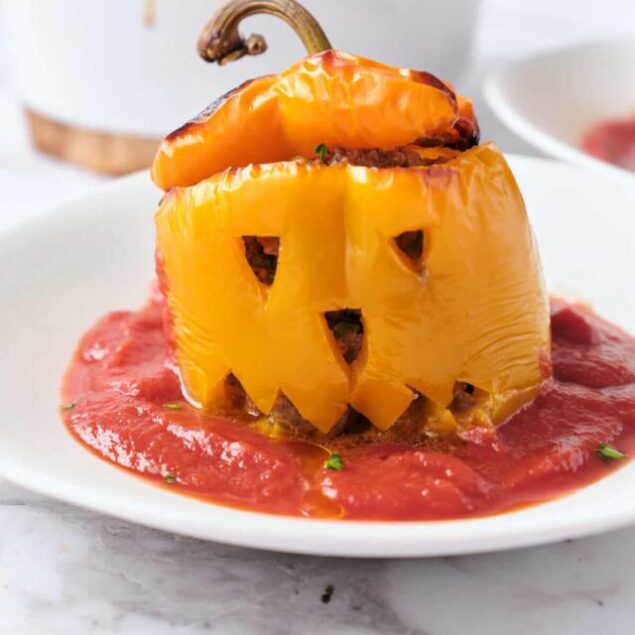 Stuffed yellow bell pepper with ground meat and melted cheese served on a bed of marinara sauce, healthy and delicious low-carb vegetable recipe. Perfect for meal prep and nutritious eating.
