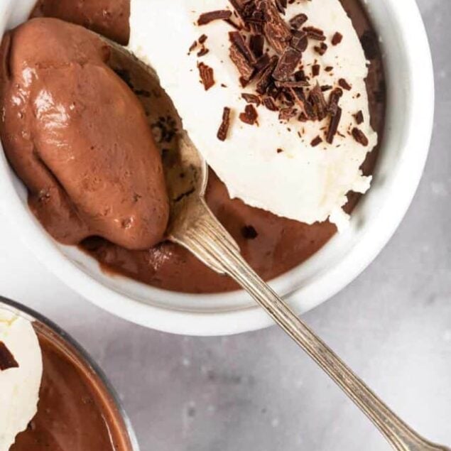 Rich chocolate pudding topped with whipped cream and chocolate shavings, perfect for healthy dessert recipes and indulgent treats.