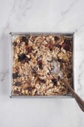 Homemade granola in a baking pan with dried fruits and oats, healthy breakfast or snack recipe, delicious and nutritious food from Food Faith Fitness.