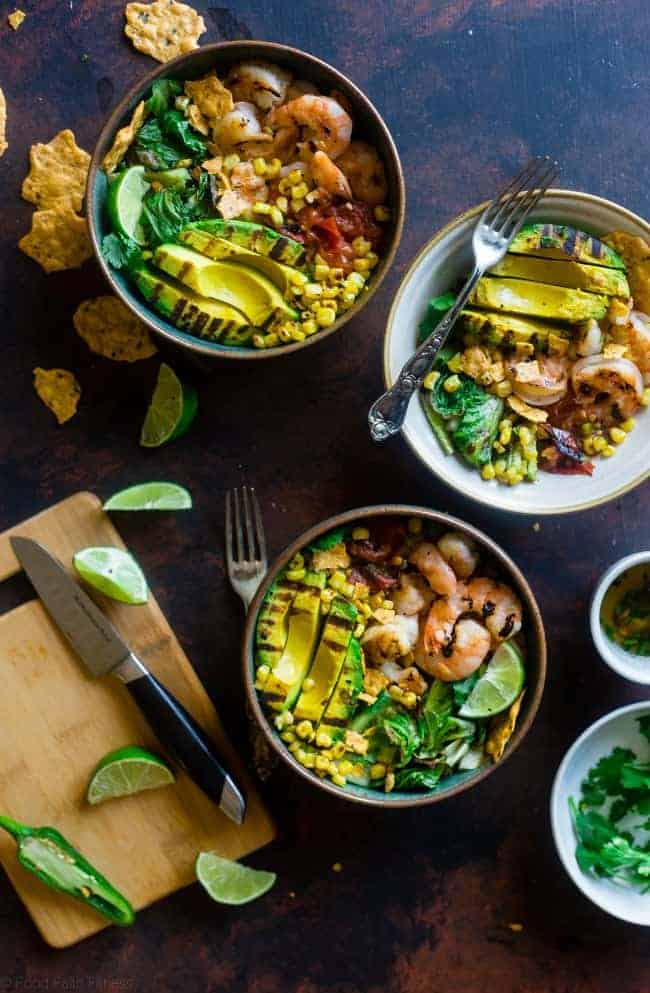Honey Lime Grilled Avocado Shrimp Nacho Bowls - These smoky-sweet bowls have glazed honey lime grilled avocado, spicy shrimp. tomato and corn! Top them with gluten free nacho chips for a healthy, summer meal that's packed with flavor! | Foodfaithfitness.com | @FoodFaithFit