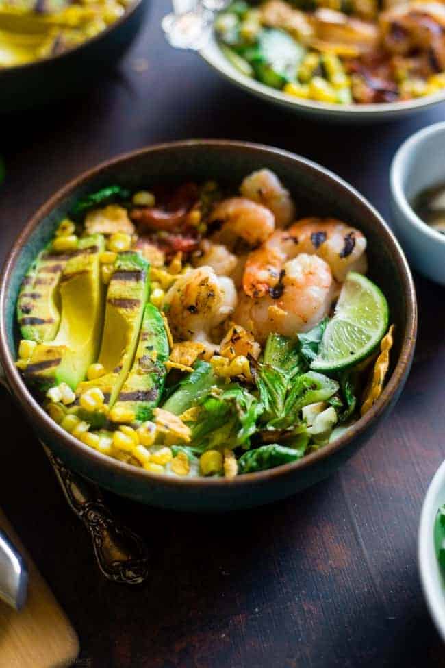 Honey Lime Grilled Avocado Shrimp Nacho Bowls - These smoky-sweet bowls have glazed honey lime grilled avocado, spicy shrimp. tomato and corn! Top them with gluten free nacho chips for a healthy, summer meal that's packed with flavor! | Foodfaithfitness.com | @FoodFaithFit
