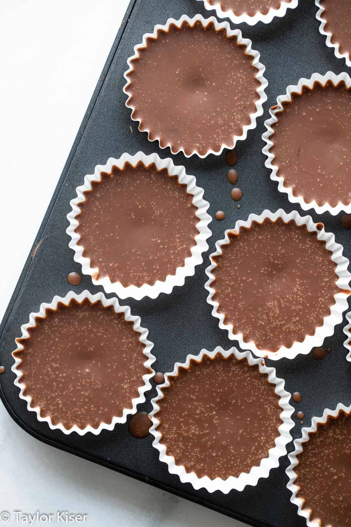 chocolate peanut butter keto fat bombs in a muffin tin