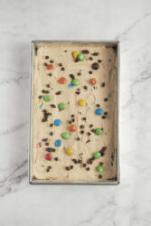 Rich, creamy homemade ice cream topped with colorful chocolate candies and M&Ms, showcasing a delicious, healthy dessert recipe from Food Faith Fitness.