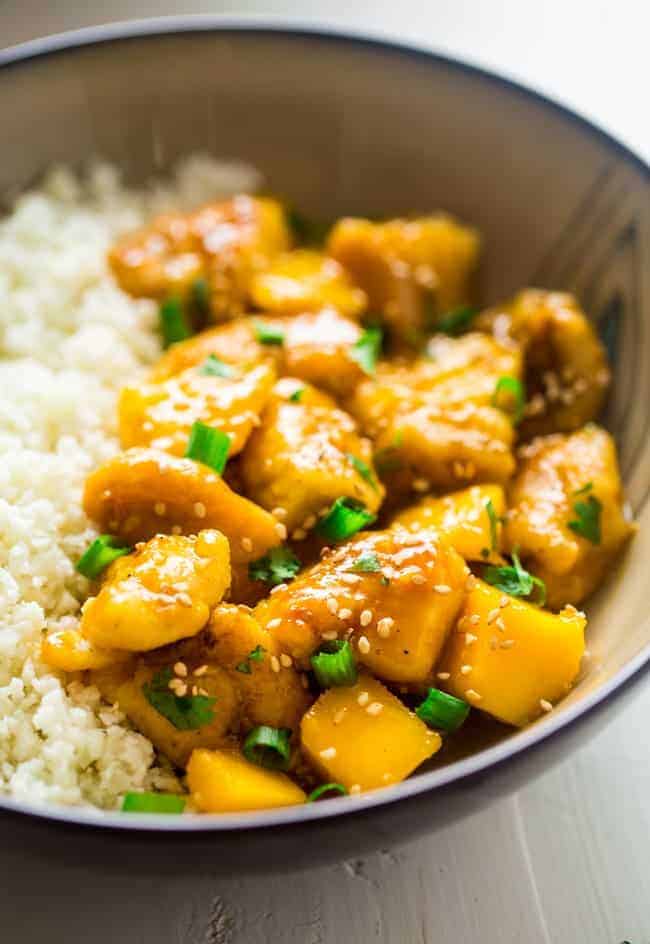 Whole 30 Mango Chicken with Coconut Cauliflower Rice - This paleo mango chicken is served over coconut cauliflower rice for a quick, easy and healthy spin on take-out that is ready in 30 mins! Recipe has a vegan option too! | Foodfaithfitness.com | @FoodFaithFit