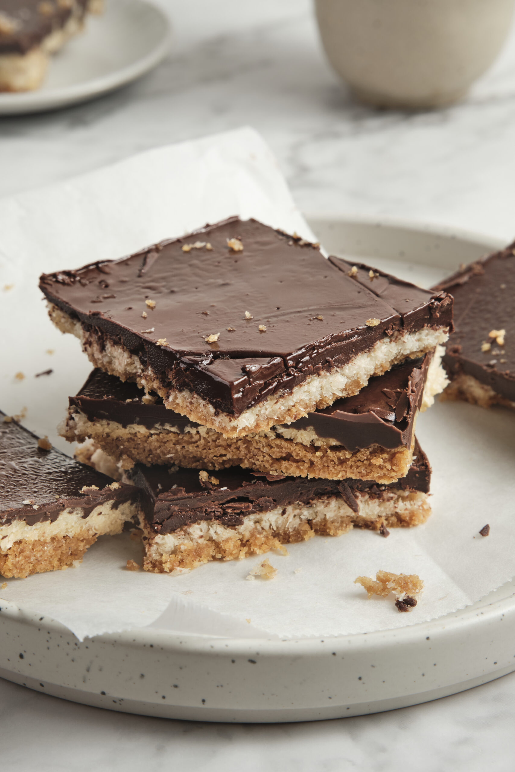 Rich chocolate layered dessert on a marble surface, showcasing delicious homemade treats with a crunchy base and smooth chocolate topping, perfect for dessert lovers and healthy eating enthusiasts.
